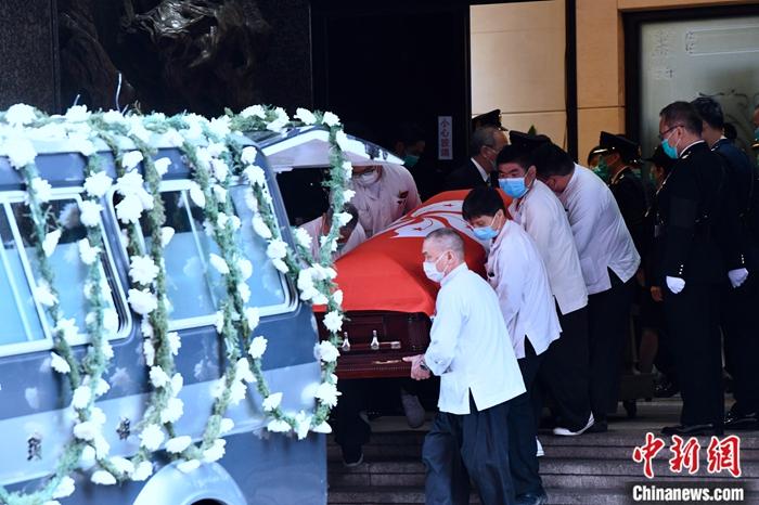 3月5日，香港海关为殉职关员吴咏敏举行最高荣誉丧礼。工作人员将特区区旗覆盖的灵柩抬上灵车。/p中新社记者 李志华 摄