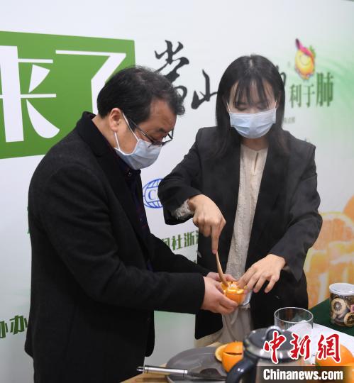 图为：常山胡柚研究院院长杨兴良(左)现场演示胡柚炖冰糖。　王刚 摄